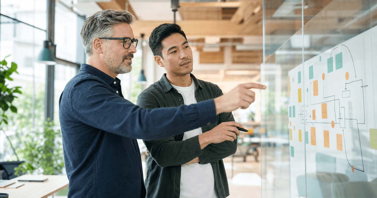 A fractional CTO reviewing a product roadmap with a startup founder at a whiteboard