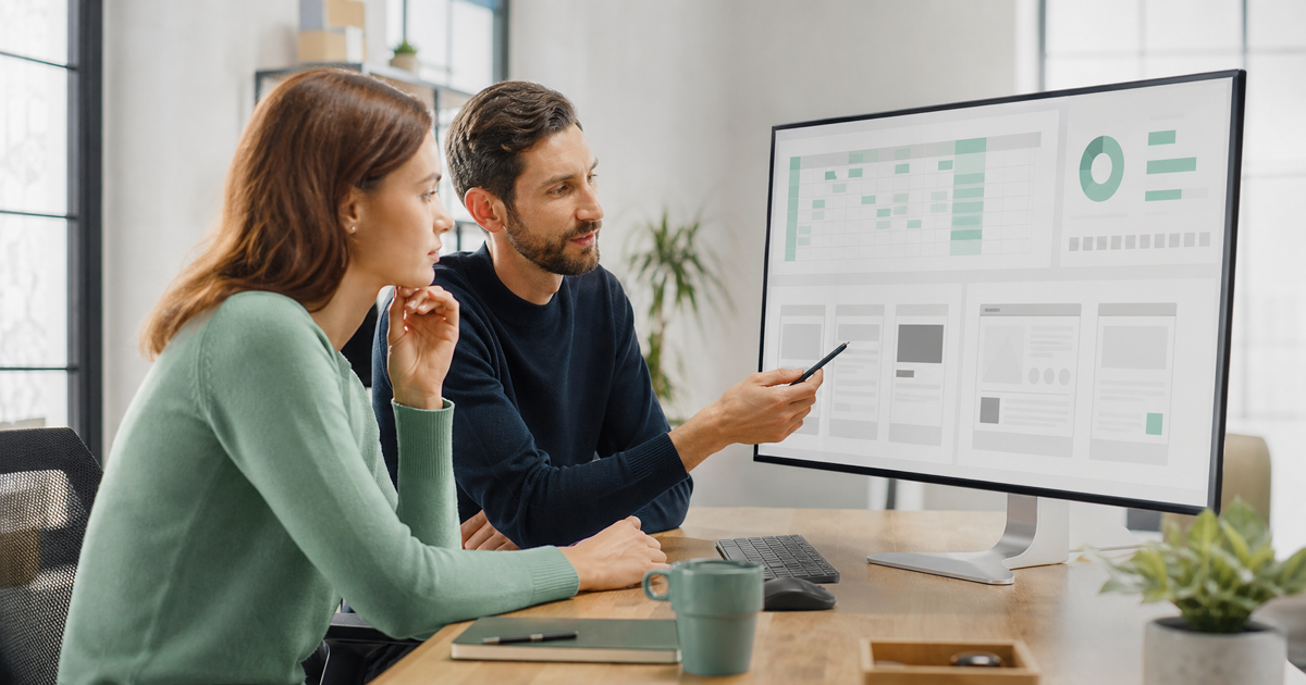 A founder and developer planning a web application budget at a desk