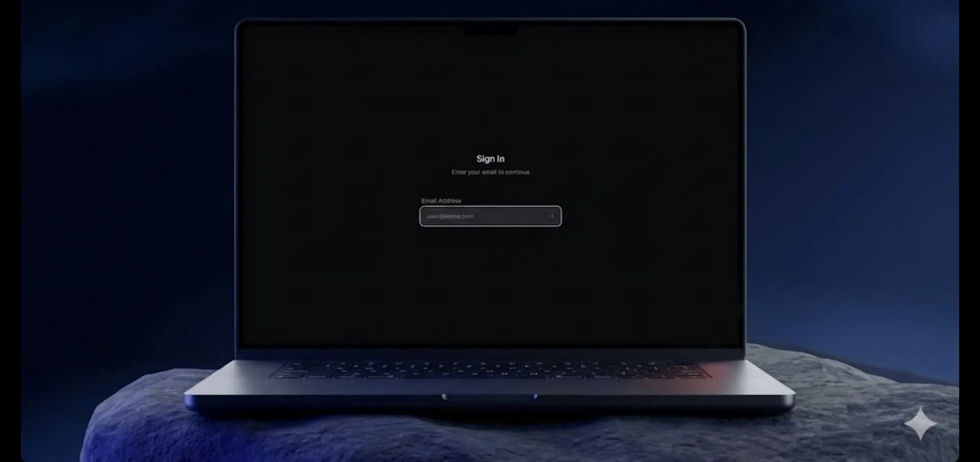 Laptop on a dark rock showing an email sign-in screen
