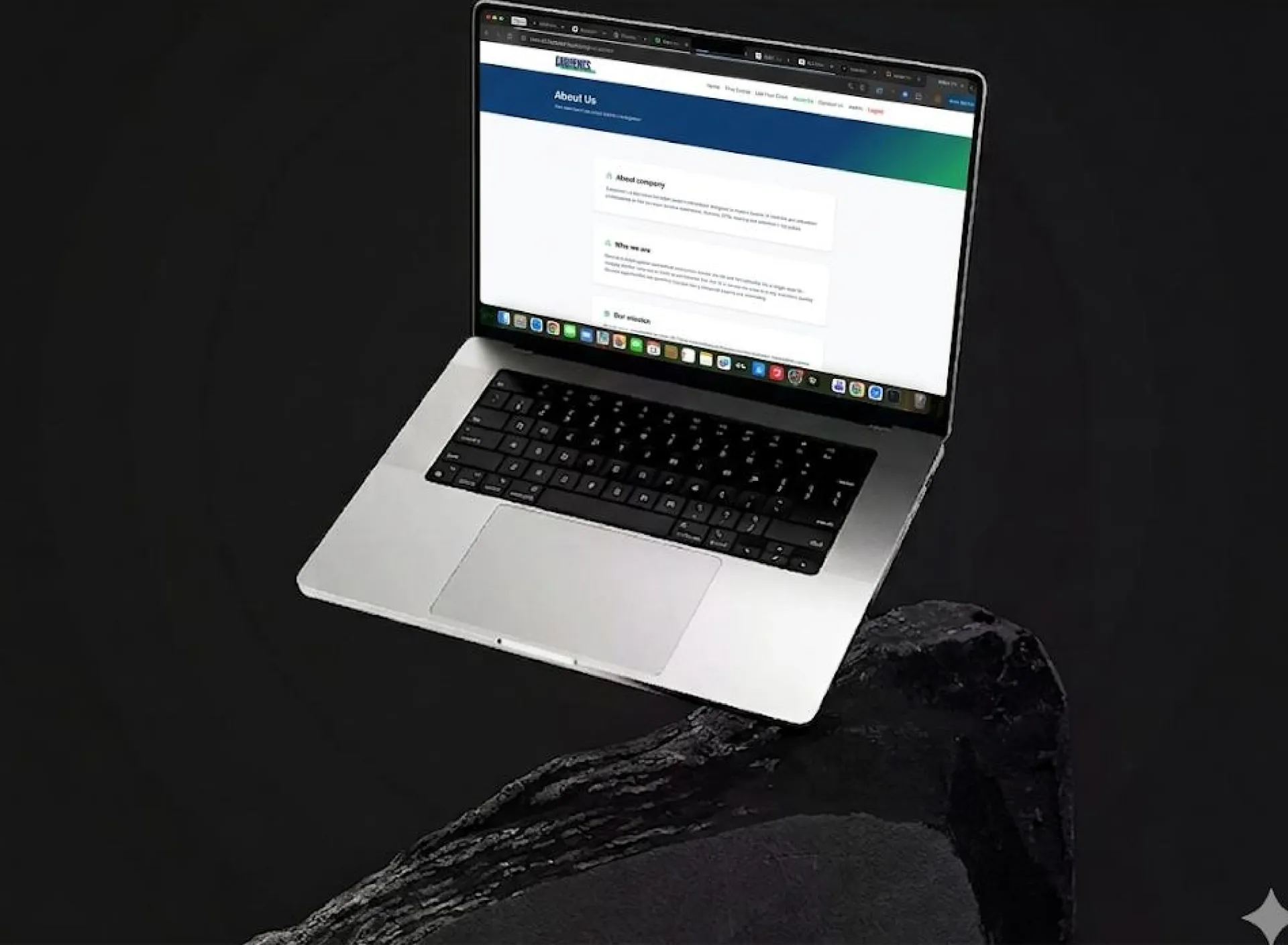 Laptop on a dark rock showing an About Us page