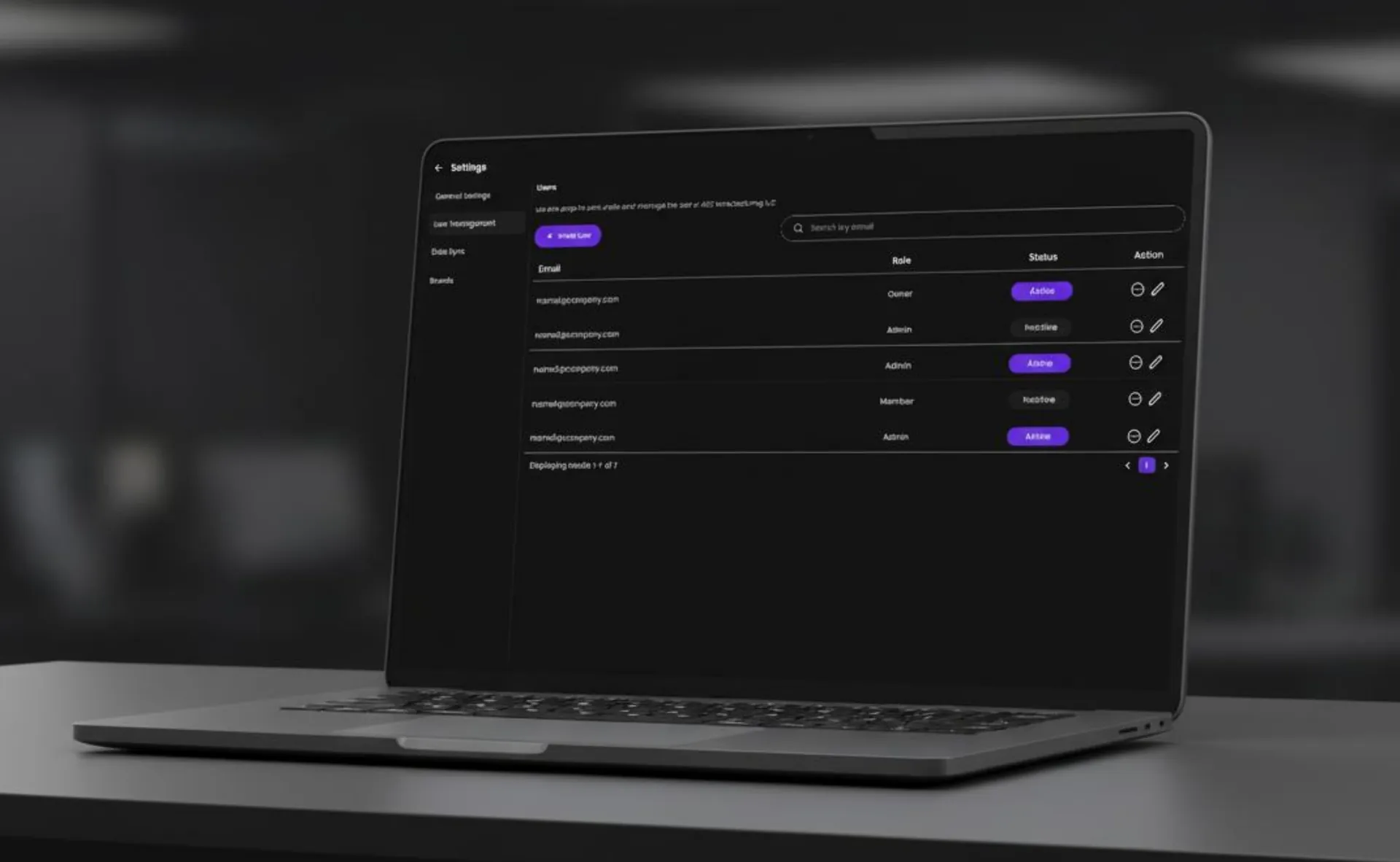 Laptop showing a user management table with roles and status badges