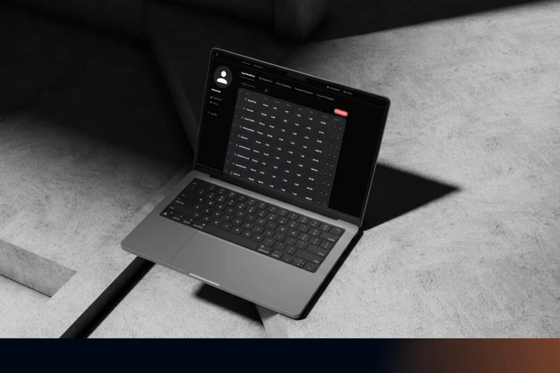 Laptop on a concrete floor showing a dark-themed table of meal templates